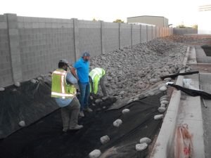 Workers spreading gravel along the boundary wall