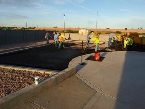 Freshly laid asphalt and a curb in front of the building